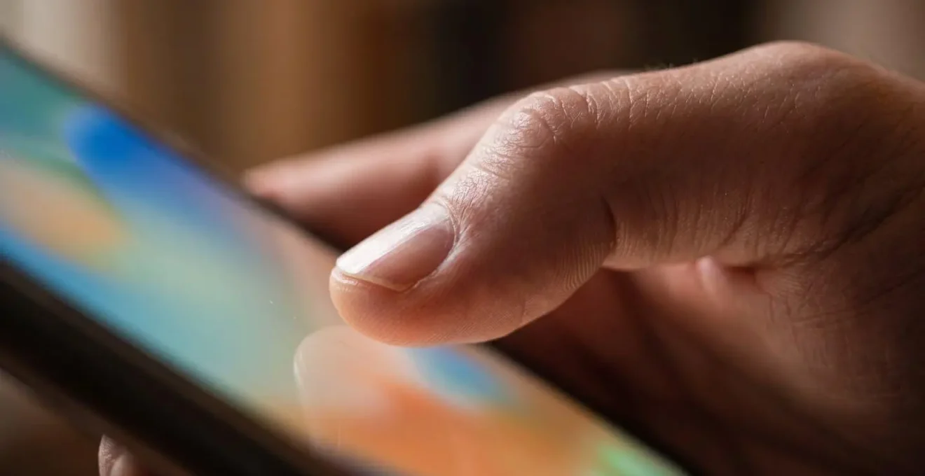 Main tenant un smartphone affichant une interface d'application d'assurance en cours de souscription