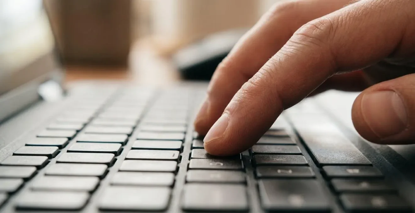 Gros plan de mains tapant sur clavier d'ordinateur pour vérification en ligne
