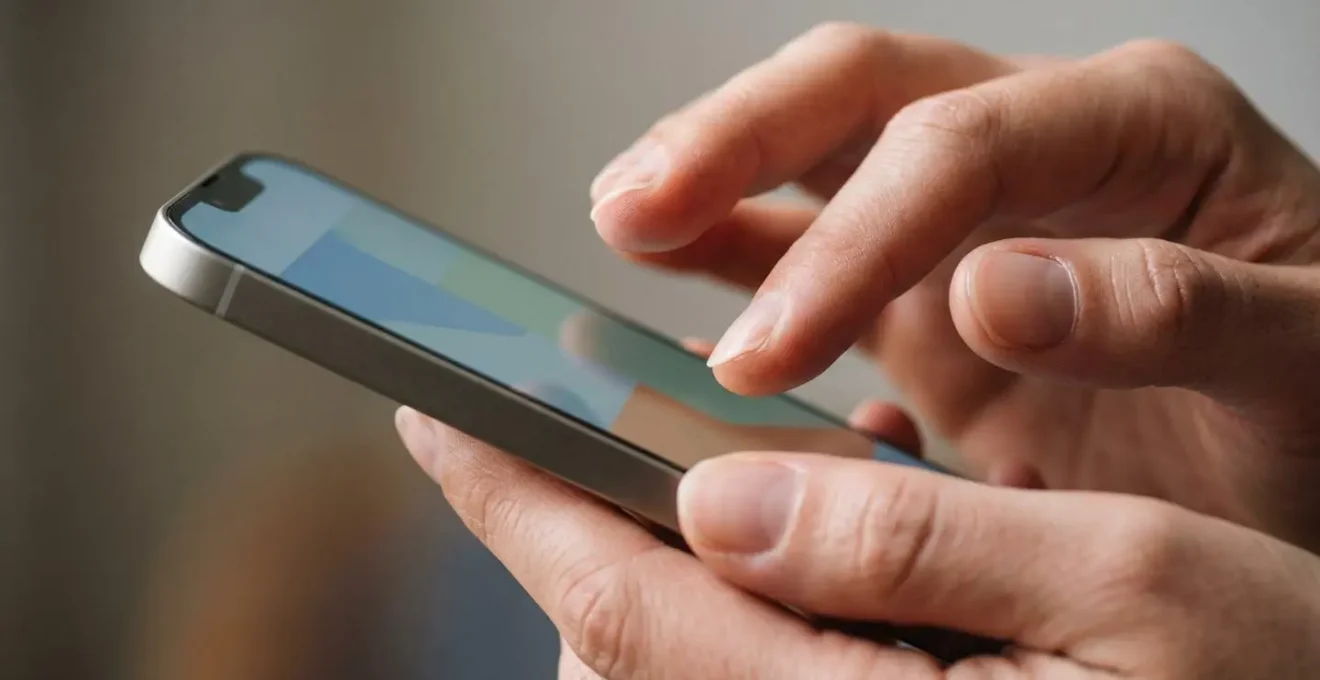 Gros plan sur des mains tenant un smartphone avec attention et concentration lors d'une validation de commande